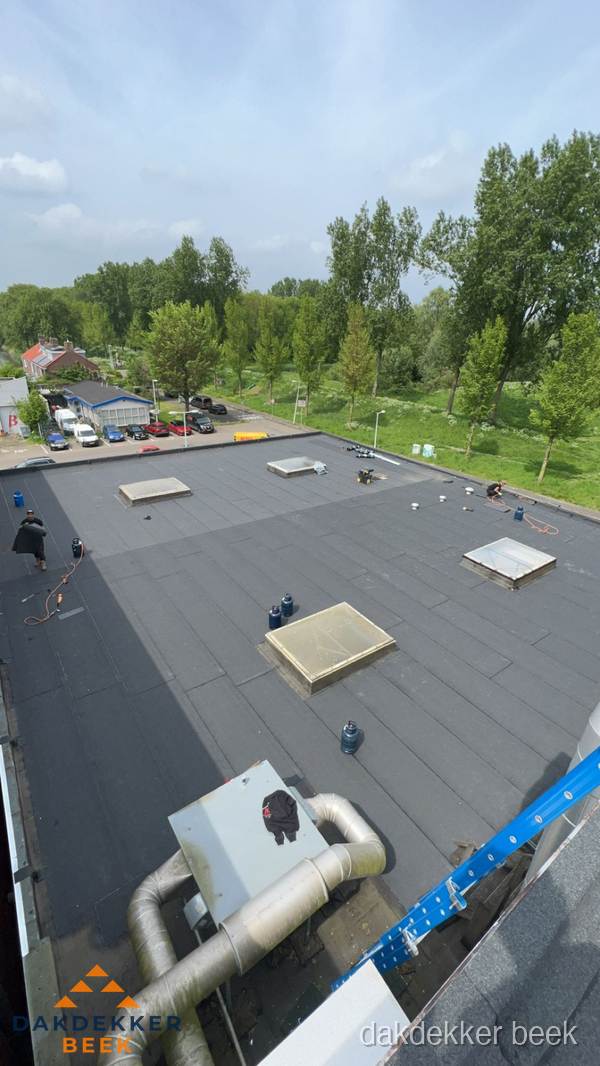 Dakdekker aan het werk op groot plat dak met bitumen in Beek Dakdekker aan het werk op groot plat dak met bitumen in Beek