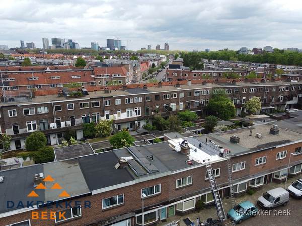 Spoed dakdekker aan het werk op plat dak in woonwijk Beek