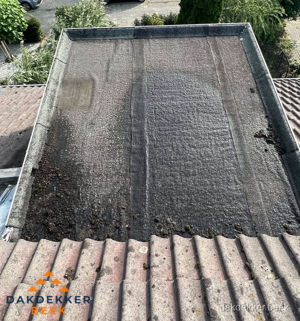 Verouderd plat dak met bitumen en slijtage voor lekkage inspectie in Beek Verouderd plat dak met bitumen en slijtage voor lekkage inspectie in Beek