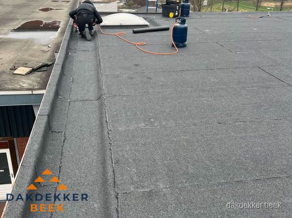 Dakdekker repareert bitumen dakbedekking op groot plat dak in Beek Dakdekker repareert bitumen dakbedekking op groot plat dak in Beek