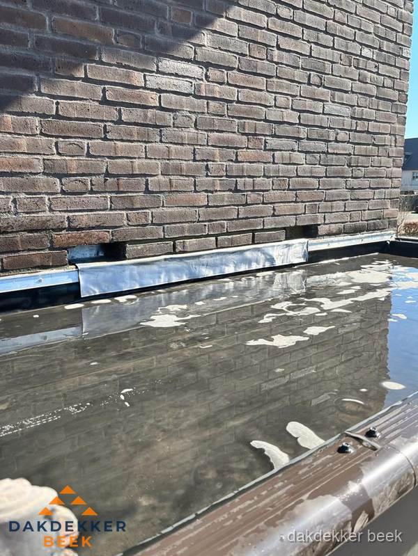 Stilstaand water op plat dak door slechte afwatering in Beek Stilstaand water op plat dak door slechte afwatering in Beek