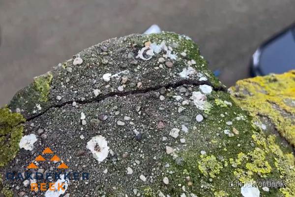 Beschadigde en verweerde nokvorst met scheuren en mos in Beek Beschadigde en verweerde nokvorst met scheuren en mos in Beek